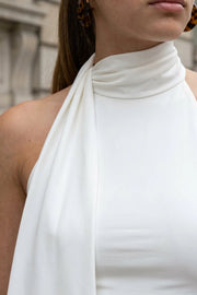 Top de fit ajustado, sin mangas, escote en espalda, cuello halter con plisados y nudo amarrable.