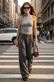 Top de fit ajustado, sin mangas, escote en espalda, cuello halter con plisados y nudo amarrable.