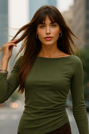Top de gamuza, fit ajustado, manga larga, cuello barco, bajo asimétrico y detalle de plisados en costado.