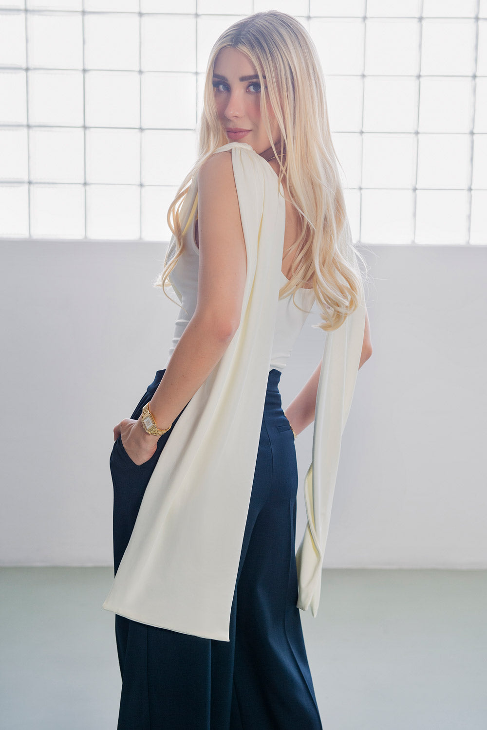 Top de fit ajustado, sin mangas, cuello redondo y detalle decorativo frontal con plisados en hombros.