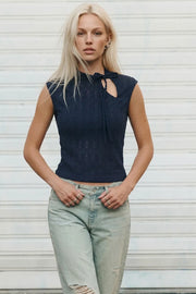 Top corto ajustado, sin mangas, cuello mao con cut out lateral y lazo amarrable. Detalle de textura en tejido.