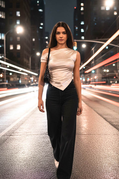 Top metálico asimétrico de fit ajustado, escote diagonal, una manga corta seguida con hombro descubierto, plisados en hombro y bajo frontal asimétrico. Detalle de plisados en costados.