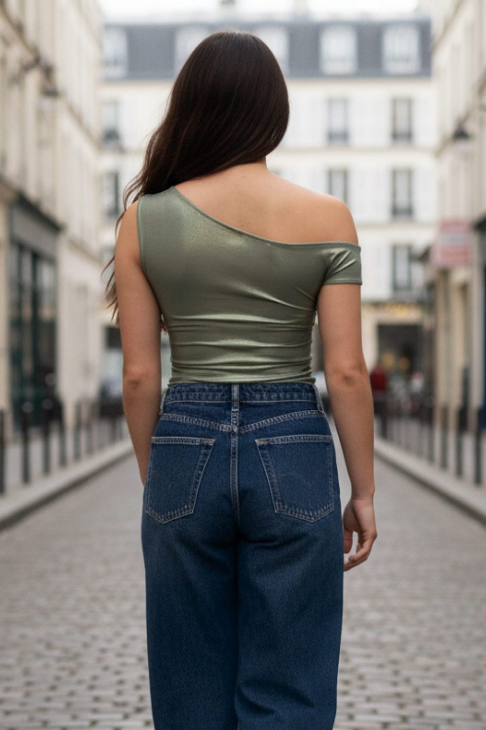 Top metálico asimétrico de fit ajustado, escote diagonal, una manga corta seguida con hombro descubierto, plisados en hombro y bajo frontal asimétrico. Detalle de plisados en costados.