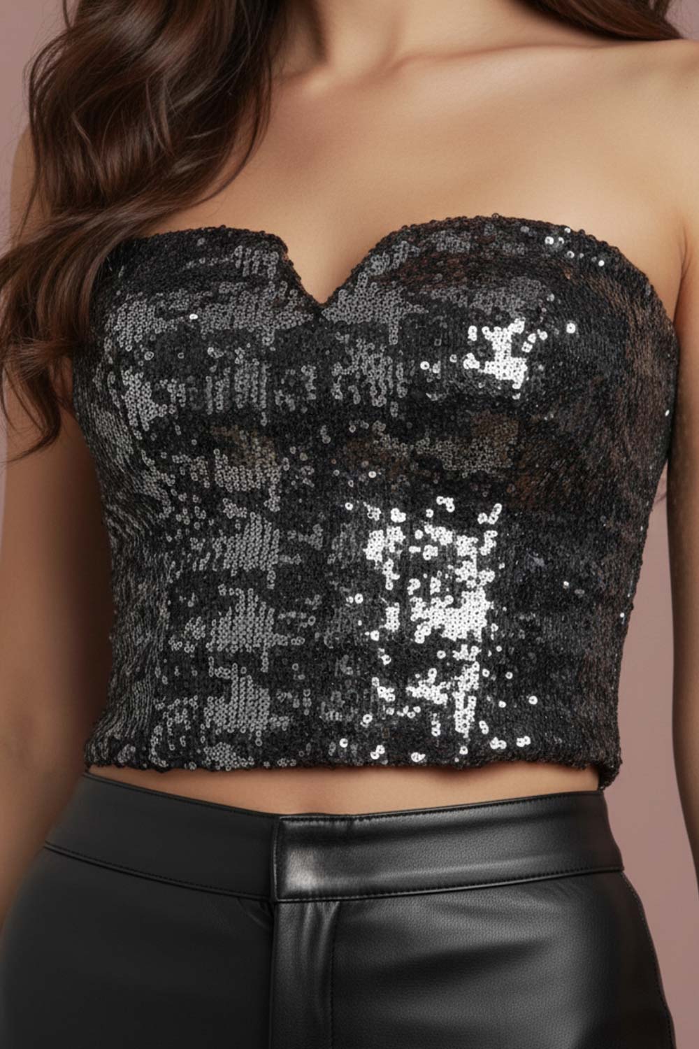 Crop top strapless de lentejuelas, estampado pata de gallo, escote corazón con detalle en v, cortes frontales y cierre posterior con cremallera visible en contraste.