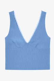 Top de fit ajustado, escote v con encaje en bordes, cortes frontales decorativos con plisados, sin mangas y detalle de textura en tejido.