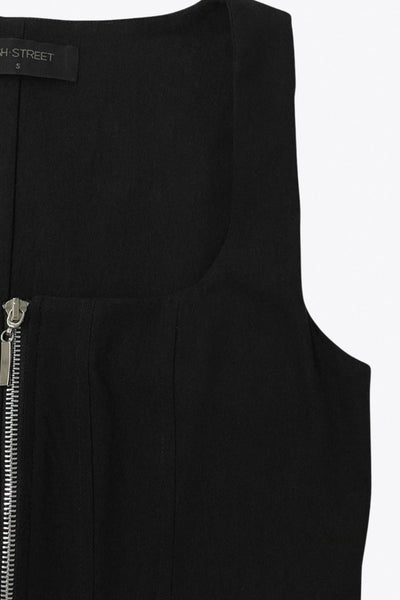 Top sin mangas de escote cuadrado, fit ajustado, pinzas con costuras decorativas y cierre frontal con cremallera visible en contraste.