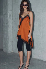 Blusa fluida larga de tirantes delgados ajustables, escote v con escote decorativo en contraste, cut out diagonal y bajo asimétrico frontal.