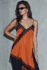 Blusa fluida larga de tirantes delgados ajustables, escote v con escote decorativo en contraste, cut out diagonal y bajo asimétrico frontal.
