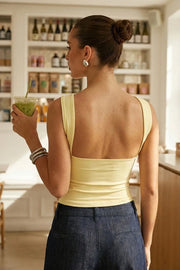 Top tubo de fit ajustado, escote recto, plisados en costados y detalle decorativo posterior de choker.