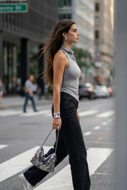 Top halter corto de fit ajustado, sin mangas, cuello halter fluido con plisados y escote en espalda. Detalle de bajo diagonal asimétrico.
