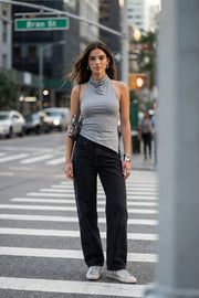 Top halter corto de fit ajustado, sin mangas, cuello halter fluido con plisados y escote en espalda. Detalle de bajo diagonal asimétrico.
