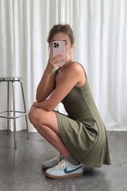 Vestido corto de escote cuadrado, sin mangas, cortes decorativos, escote en espalda y corte en a con olanes en bajo.