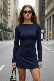 Vestido corto ajustado, de corte en a, cuello barco, manga larga, plisados laterales en cintura y detalle de textura en tejido.