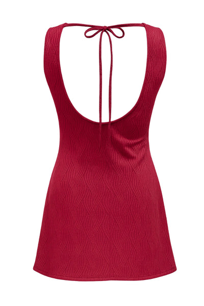 Vestido corto de fit recto, sin mangas, cuello barco y escote en espalda con lazo amarrable posterior. Detalle de textura en tejido.