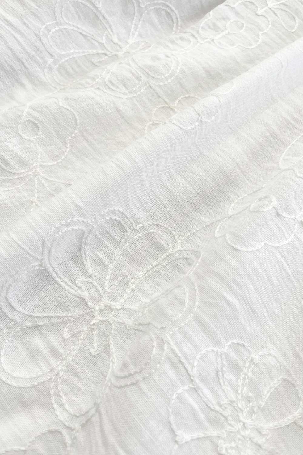 Vestido corto bordado, de talle fruncido, escote v, manga corta abullonada con rib elástico en bordes y corte en a con olanes en bajo.