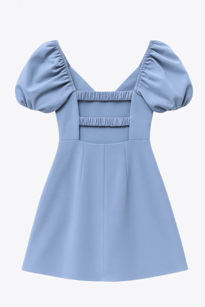 Vestido corto de fit ajustado, manga corta abullonada con rib elástico en bordes, corte en cintura, cut out en espalda con doble elástico plisado y cierre posterior con cremallera oculta.