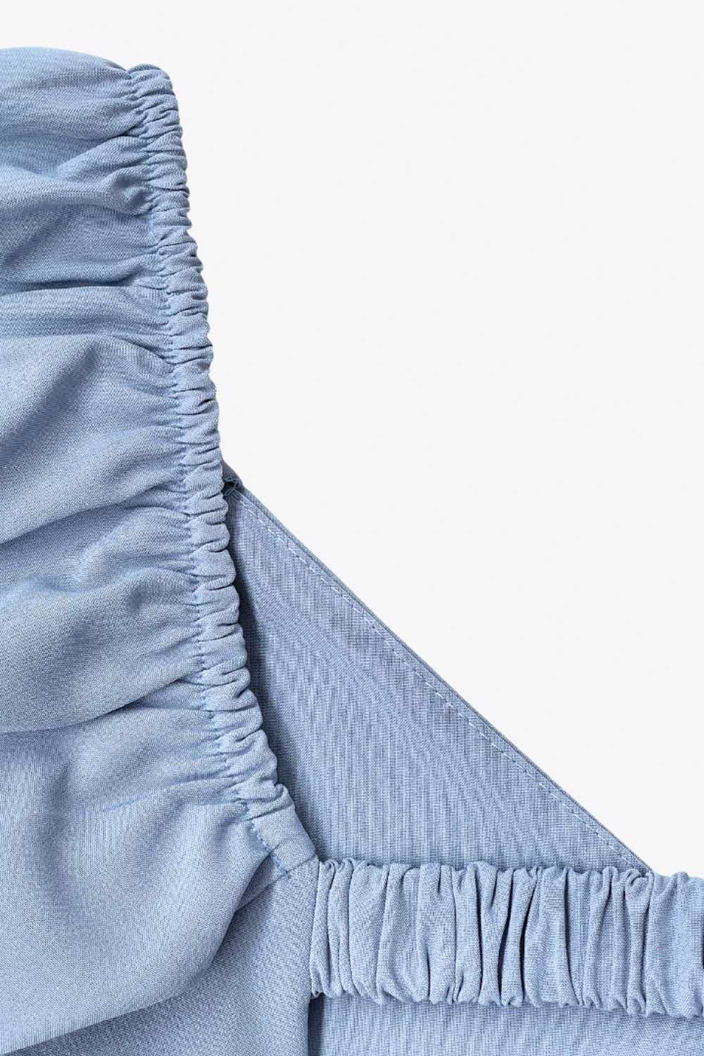 Vestido corto de fit ajustado, manga corta abullonada con rib elástico en bordes, corte en cintura, cut out en espalda con doble elástico plisado y cierre posterior con cremallera oculta.