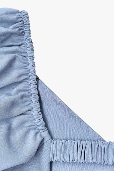 Vestido corto de fit ajustado, manga corta abullonada con rib elástico en bordes, corte en cintura, cut out en espalda con doble elástico plisado y cierre posterior con cremallera oculta.