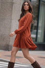 Vestido corto de fit fluido, escote v, manga 3/4 abullonada con rib elástico en puños y plisados decorativos laterales con elástico.