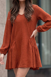 Vestido corto de fit fluido, escote v, manga 3/4 abullonada con rib elástico en puños y plisados decorativos laterales con elástico.