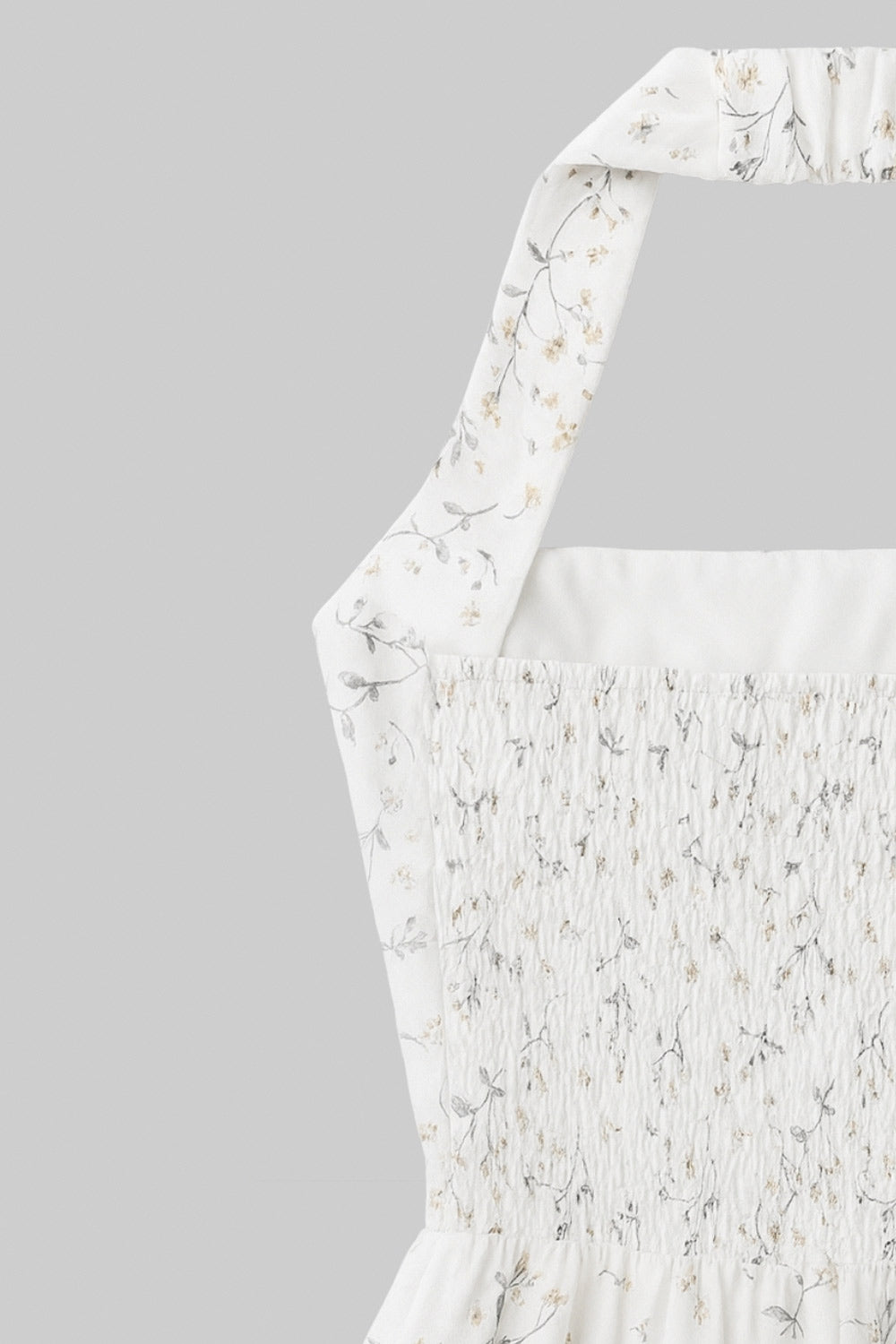 Vestido corto de estampado floral, cuello halter con rib elástico, sin mangas, escote recto, cortes frontales, detalle frontal v en cintura con plisados y fruncido en espalda.