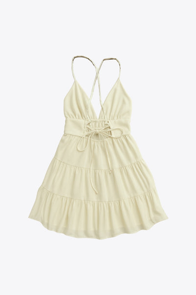 Vestido corto de escote v, corte en a con capas de olanes en bajo, rib elástico en cintura, tirantes delgados con lazado ajustable posterior y escote en espalda.