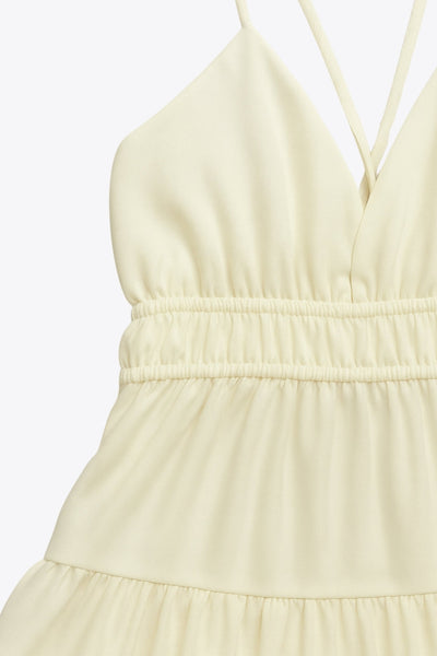 Vestido corto de escote v, corte en a con capas de olanes en bajo, rib elástico en cintura, tirantes delgados con lazado ajustable posterior y escote en espalda.