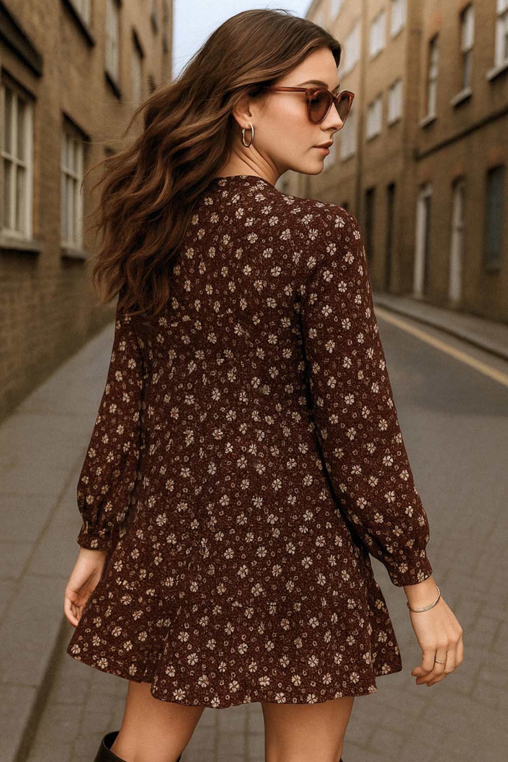 Vestido corto de estampado floral, fit fluido, manga larga con puño abotonado, escote v cruzado y plisado en cintura con olanes en bajo.