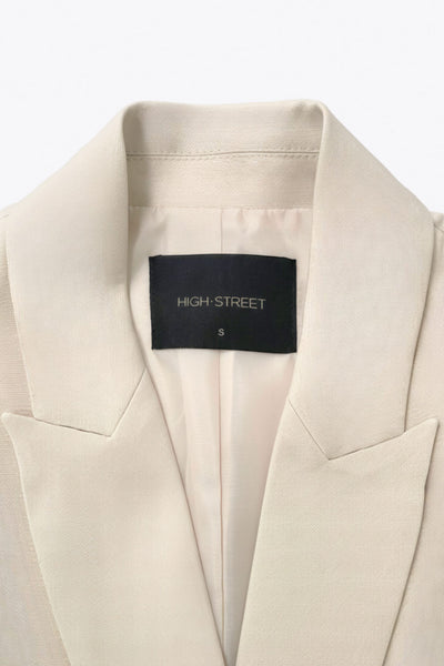 Vestido chaleco con solapa y con doble cruce de botón en contraste. Detalle de bolsillos frontales con cartera, trabillas y cinturón amarrable del mismo tejido.