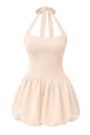 Vestido corto globo de bouclé, cuello halter con lazo amarrable posterior, fit ajustado, escote cuadrado, pinzas frontales, bajo con acabado en volumen y plisados en cadera. Cierre posterior con cremallera visible en contraste.