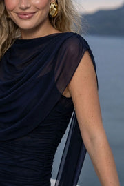 Vestido largo de mesh con plisados, fit ajustado, cuello barco, manga corta seguida, detalle decorativo con plisados frontales, en hombros y costados. Detalle de transparencia en bajo.