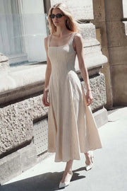 Vestido midi de corte en a, tirantes, estampado rayas, escote cuadrado y cortes decorativos. Cierre lateral con cremallera oculta.