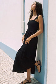 Vestido maxi de tirantes con nudo amarrable, talle fruncido, escote recto y corte en a con capas de olanes en bajo.