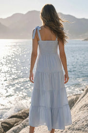 Vestido maxi de tirantes con nudo amarrable, talle fruncido, escote recto y corte en a con capas de olanes en bajo.