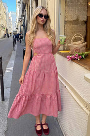 Vestido largo de corte en a, estampado cuadros, tirantes delgados con nudo amarrable, bajo con capas de olanes, cut out en costados y espalda. Detalle de rib elástico en cintura y fruncido en espalda.