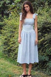 Vestido midi de estampado cuadros, tirantes con nudo amarrable, escote recto con cortes y plisados decorativos, corte en a, plisados en cintura con corte frontal en v y fruncido en espalda.