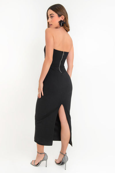 Vestido midi de fit ajustado, strapless, escote recto y detalle de cut outs frontales. Cierre posterior con cremallera visible en contraste y abertura en bajo.