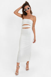 Vestido midi de fit ajustado, strapless, escote recto y detalle de cut outs frontales. Cierre posterior con cremallera visible en contraste y abertura en bajo.