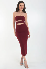 Vestido midi de fit ajustado, strapless, escote recto y detalle de cut outs frontales. Cierre posterior con cremallera visible en contraste y abertura en bajo.