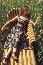 Vestido midi estampado de tirantes con nudo amarrable, escote recto y corte en a. Detalle de fruncido en espalda y bajo con olanes.