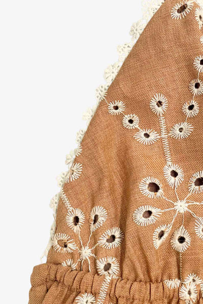 Vestido midi bordado de fit fluido, corte en a, tirantes delgados ajustables, escote v, bajo con capas de olanes y escote en espalda con lazo amarrable posterior. Detalle de rib elástico en cintura y bordado con perforado en tejido.