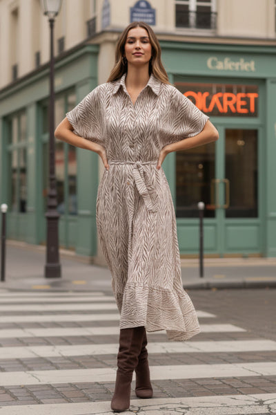 Vestido midi camisero, estampado, de fit fluido, manga corta amplia con olanes, cuello camisero, cinturón amarrable del mismo tejido, pinza de amplitud en espalda y olanes en bajo asimétrico. Detalle de bies en contraste.