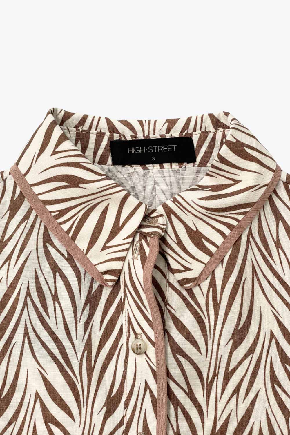 Vestido midi camisero, estampado, de fit fluido, manga corta amplia con olanes, cuello camisero, cinturón amarrable del mismo tejido, pinza de amplitud en espalda y olanes en bajo asimétrico. Detalle de bies en contraste.