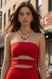 Vestido midi de fit ajustado, strapless, escote recto y detalle de cut outs frontales. Cierre posterior con cremallera visible en contraste y abertura en bajo.