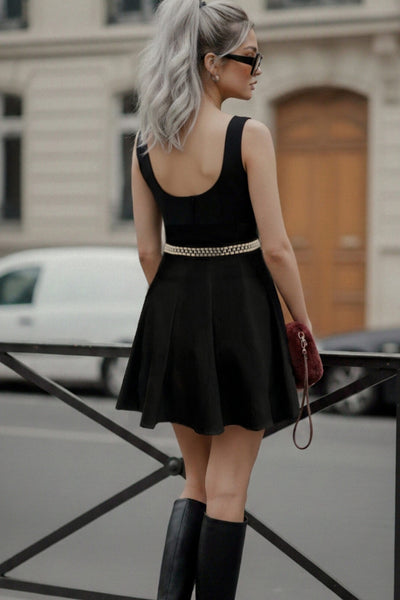 Vestido corto de cuello barco, sin mangas, cortes frontales, escote en espalda y corte en a con olanes en bajo.