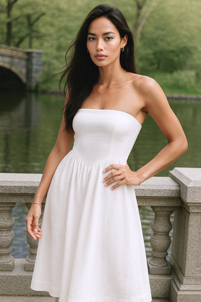 Vestido midi strapless de escote recto, fit ajustado, detalle v frontal en cintura con plisados, corte en a y cierre lateral con cremallera oculta.