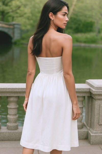 Vestido midi strapless de escote recto, fit ajustado, detalle v frontal en cintura con plisados, corte en a y cierre lateral con cremallera oculta.