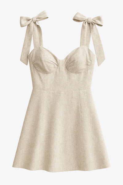 Vestido corto de tirantes con nudo amarrable, escote corazón con cortes y plisados, fit ajustado, corte en a y cierre posterior con cremallera oculta.