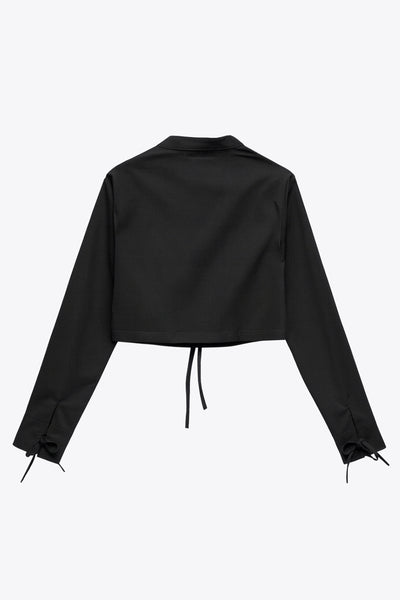 Camisa corta de fit recto, manga larga con puño y lazado decorativo, cuello mao y cierre frontal con lazado amarrable.