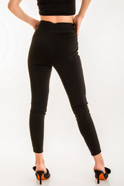 Legging de fit ajustado, cintura alta con pretina elástica y botones frontales decorativos.